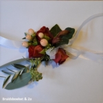 Polscorsage op lintjes met rode roos en peach kleurige hypericum bes Polscorsage