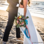 Trouwboeket met vrolijke kleuren in oranje, geel en roze met eucalyptus en loshangende linten Trouwboeket met vrolijke kleuren in oranje, geel en roze met eucalyptus en loshangende linten